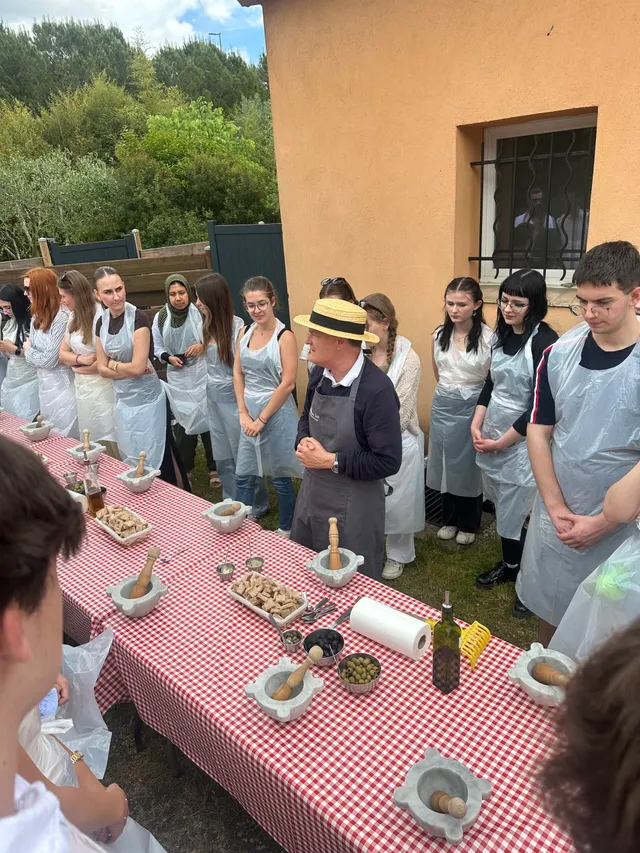 Schülerinnen und Schüler mit Schürzen bei einem Kochkurs im Freien