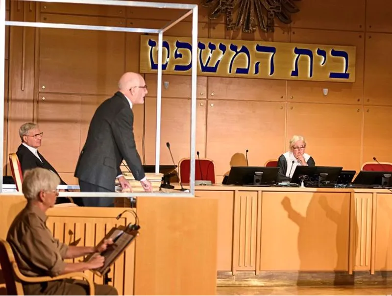 Szene aus „Eichmann vor Gericht“: Darsteller im nachgebauten Gerichtssaal, einer davon in einer Glaskabine